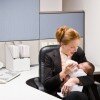 businesswoman feeding baby at desk