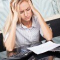 Sad woman looks at the bill. Female working at home